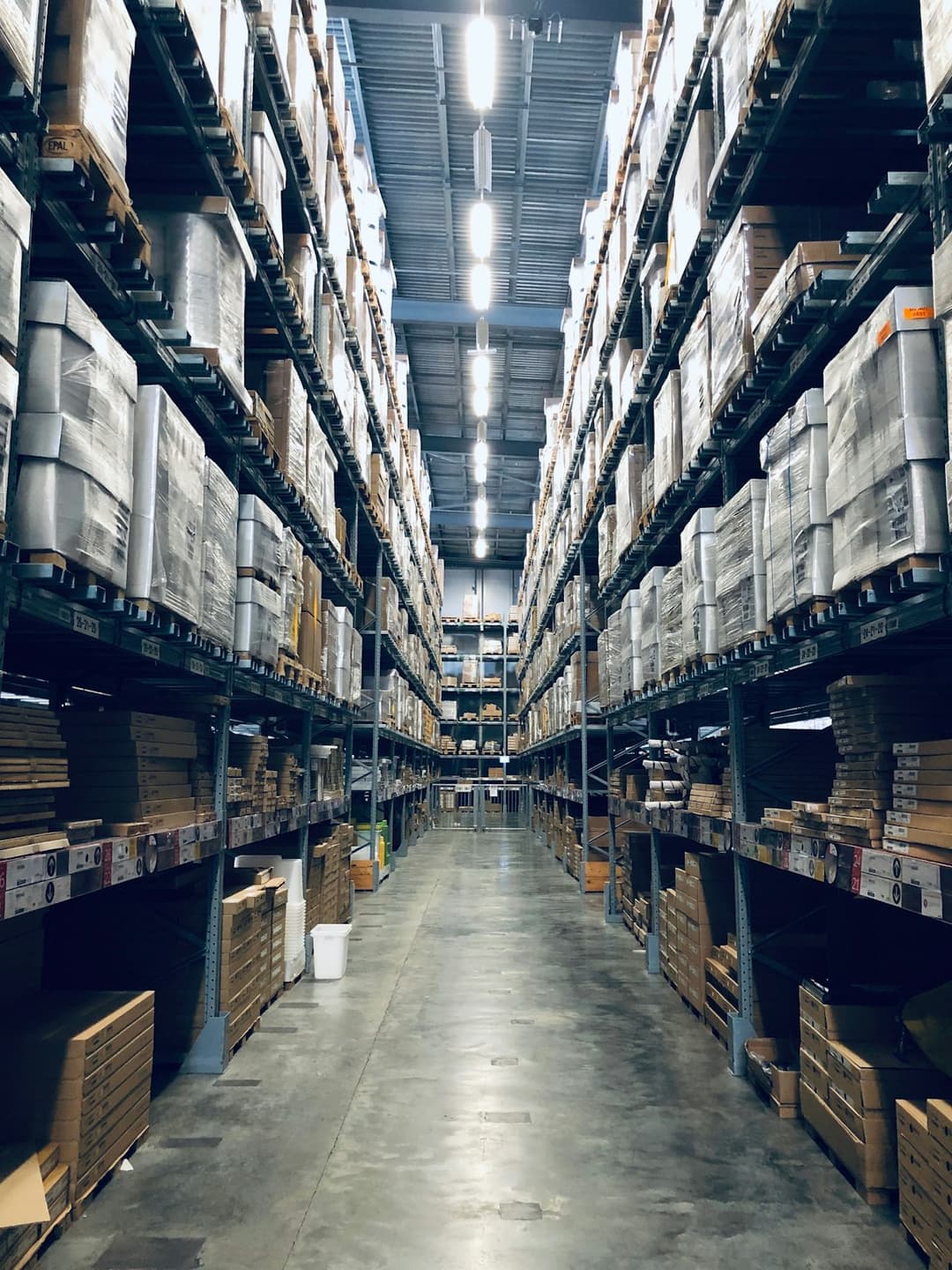 High-bay logistics warehouse aisle with racked pallets